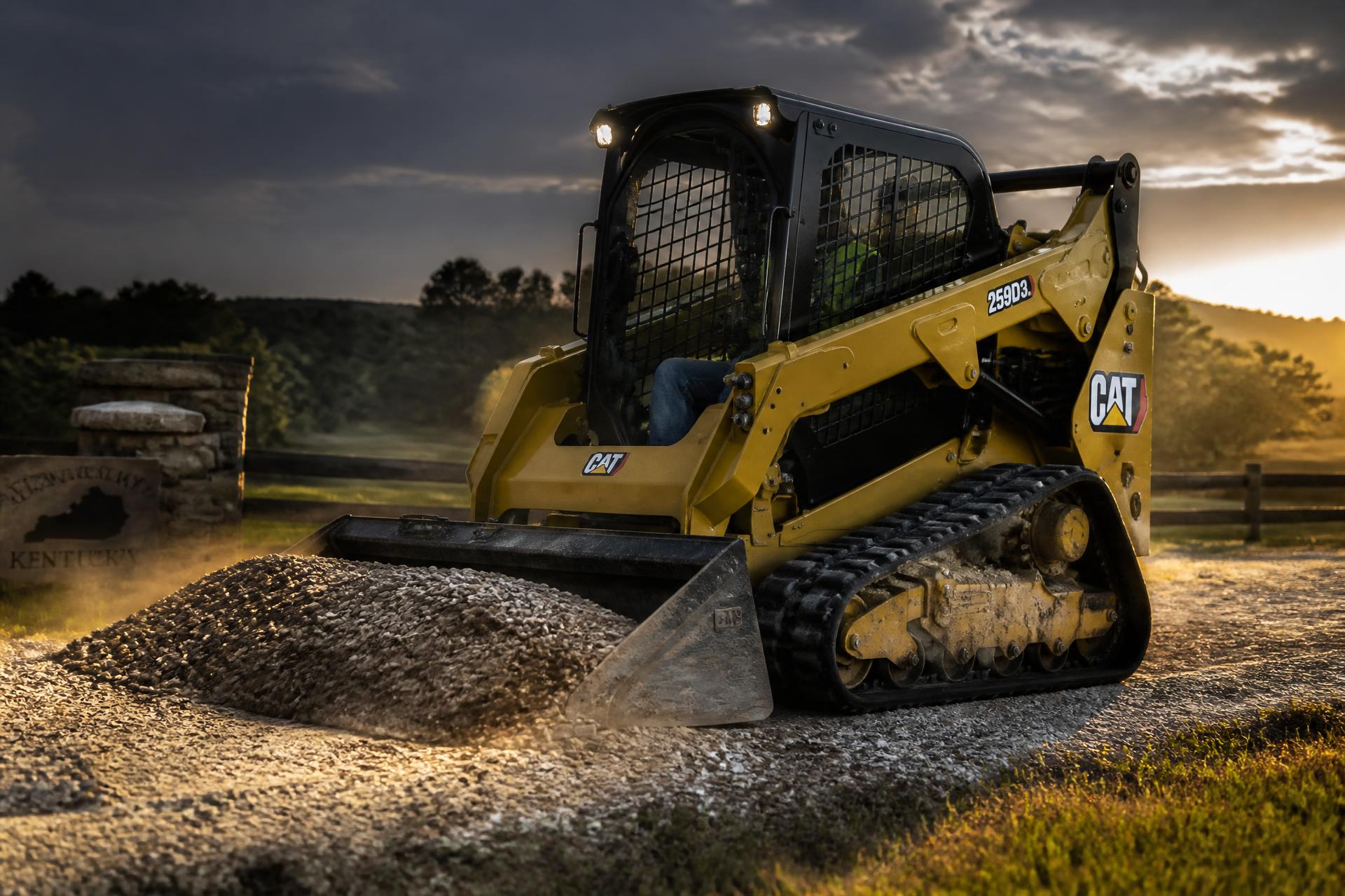 CAT 259D3 skid steer pushing gravel on a Kentucky driveway